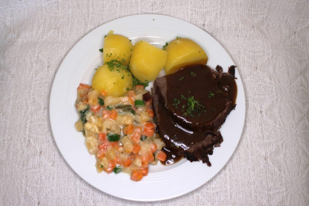 Geschmorter Ochsenhüfte, gestovten Karotten- und Steckrübengemüse, Rinderbratensoße mit Preißelbeeren und Salzkartoffeln